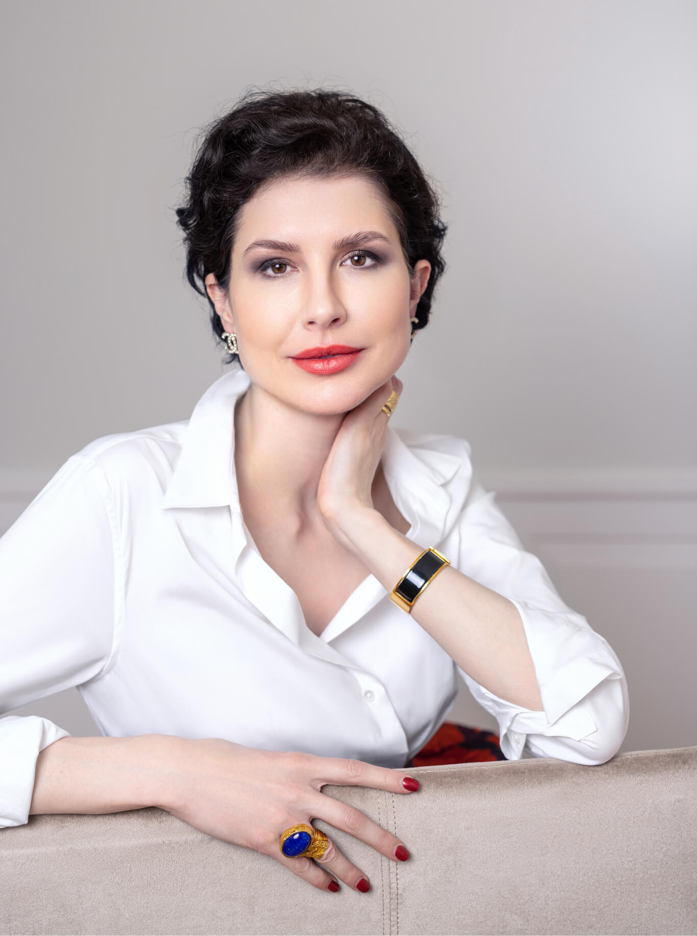 Dr. Liv Kraemer wearing a white shirt, resting her head on her hand.