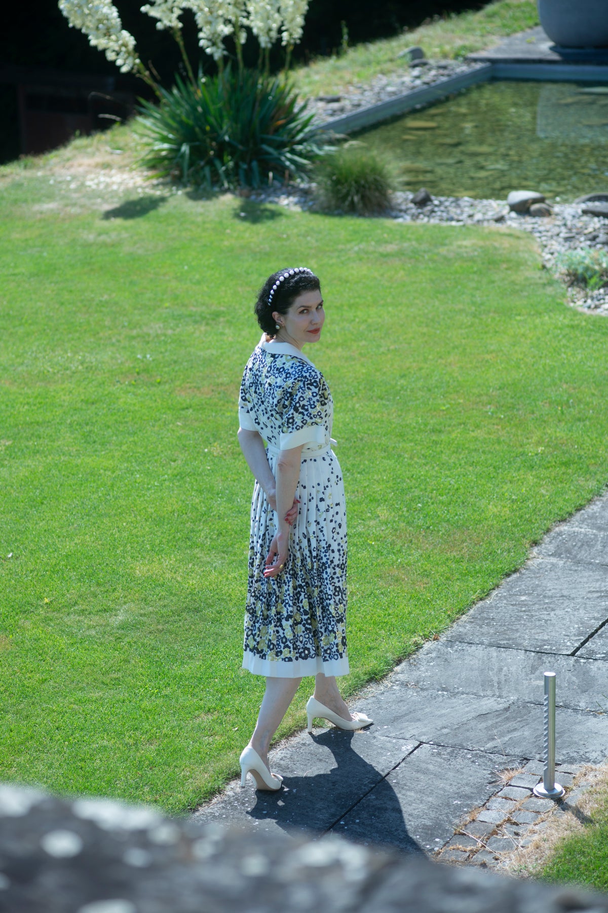 Dr. Liv Kraemer in a floral dress walking on a grassy path entering the Liv World by combining science and luxury