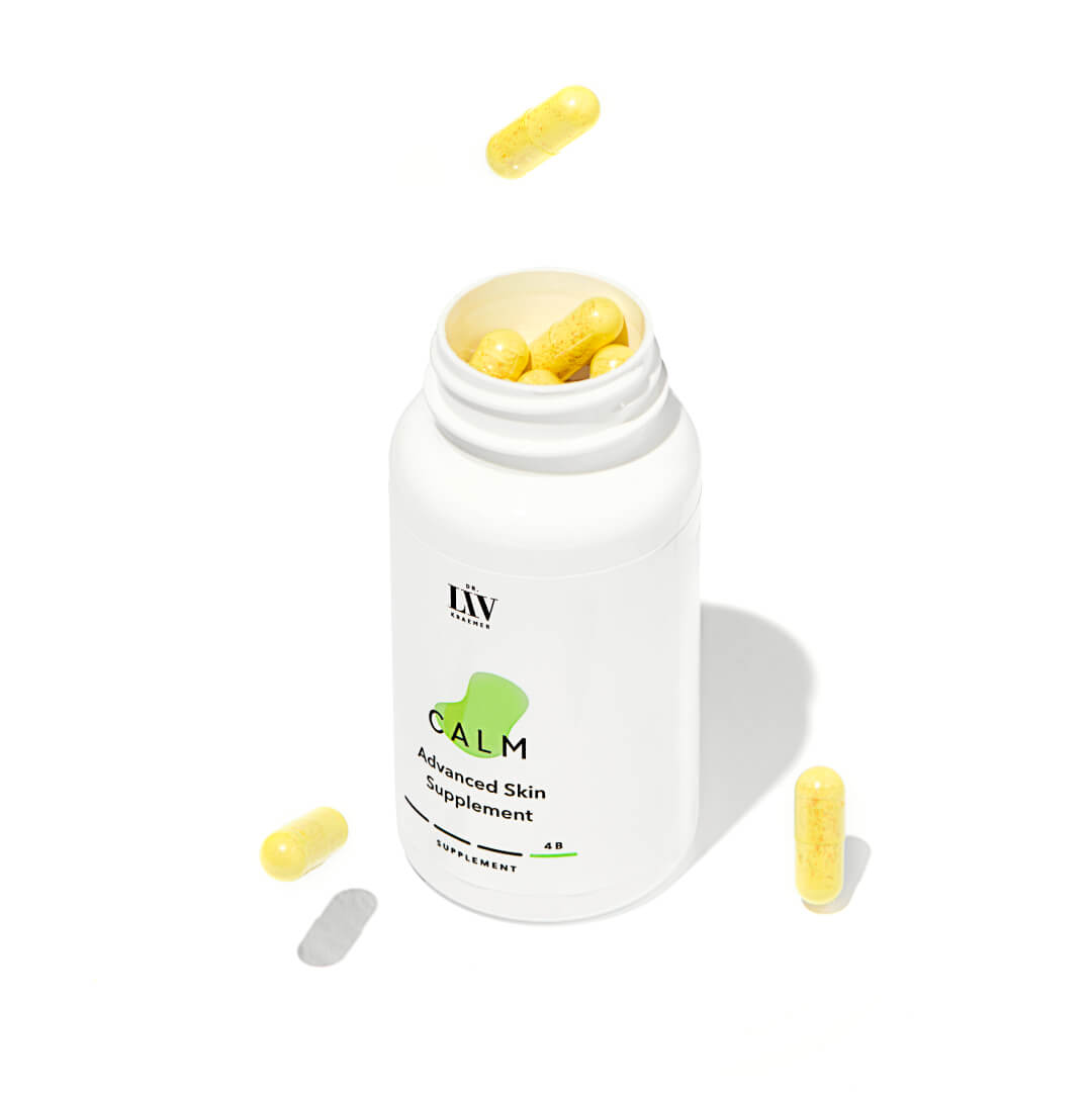 A bottle and box of board certified dermatologist Dr. Liv Kraemers Calm Advanced Skin Supplement, with a an open lid, letting the capsules show, against a white background.